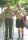 Two adults walking down sidewalk.